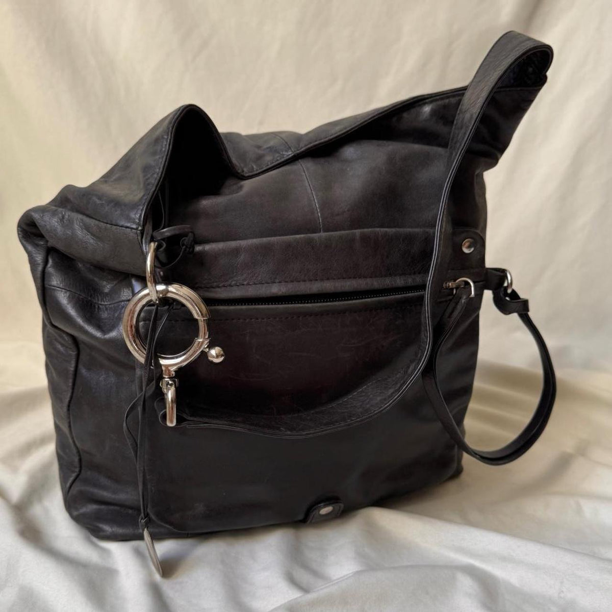 Y2k distressed black leather bag with chunky silver hardware.