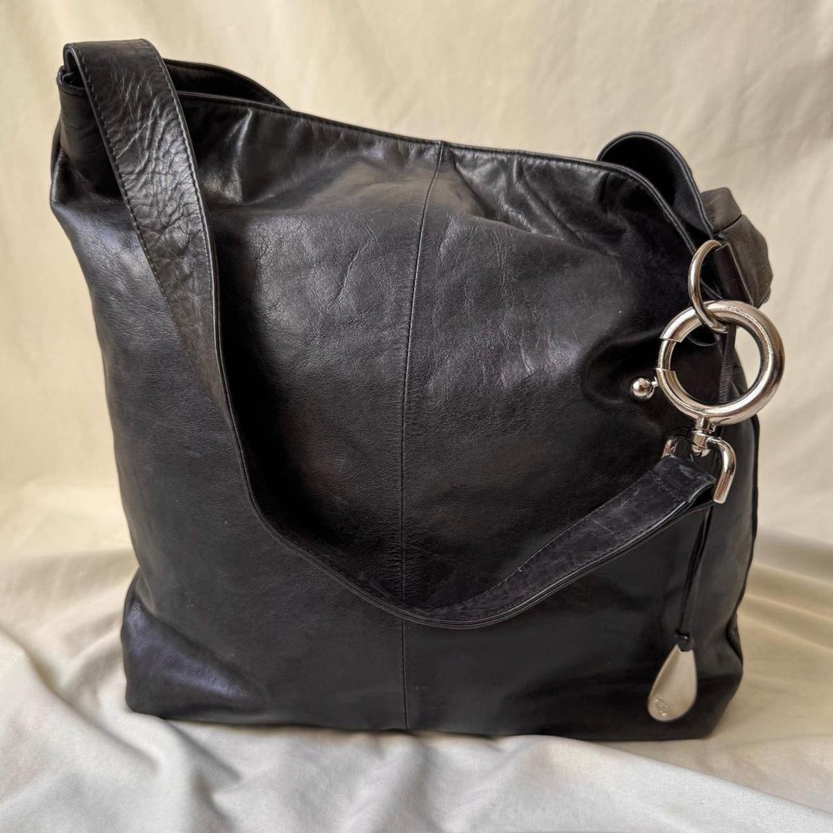 Y2k distressed black leather bag with chunky silver hardware.