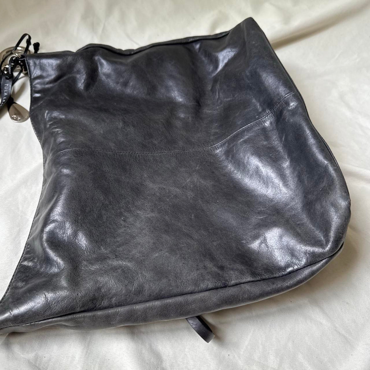 Y2k distressed black leather bag with chunky silver hardware.