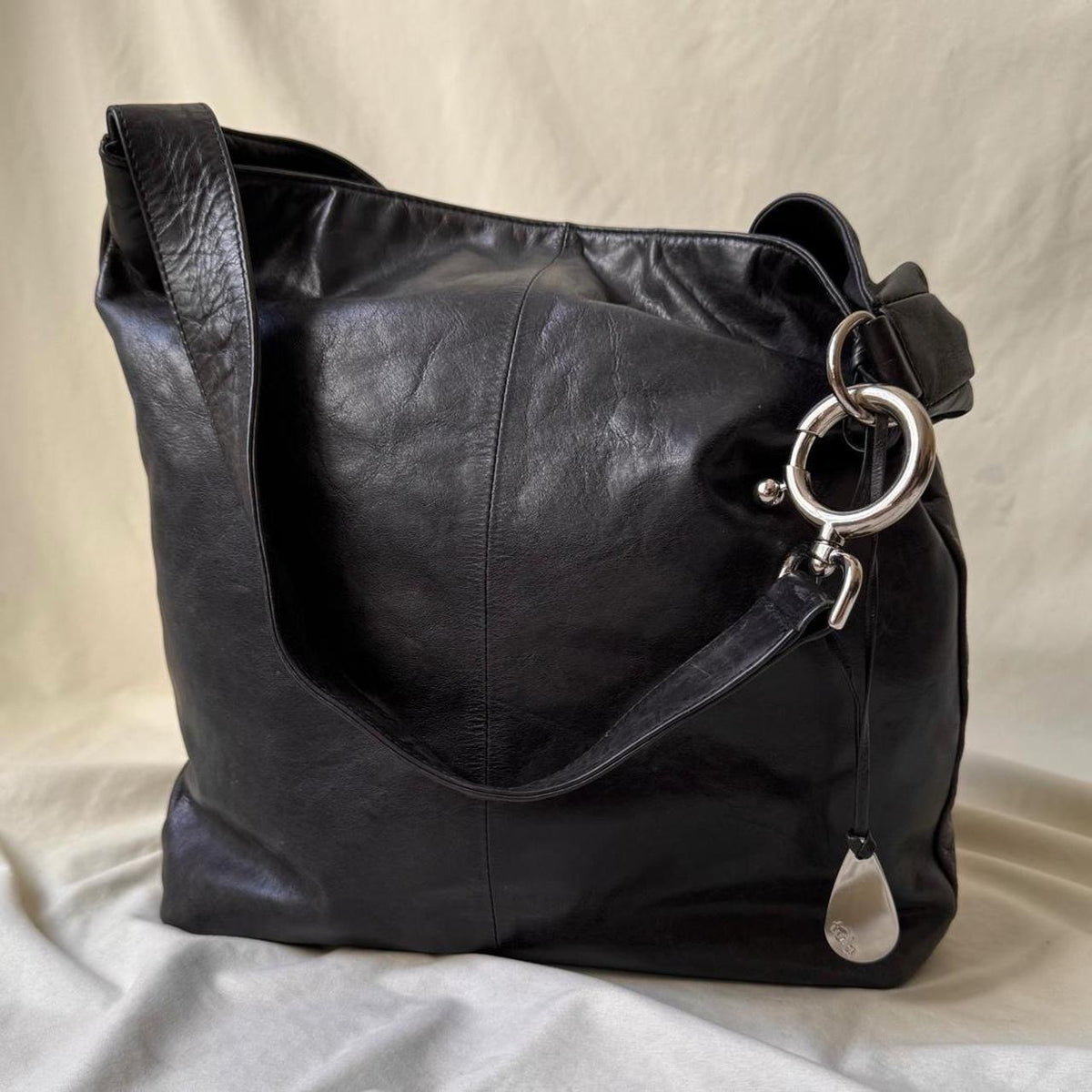 Y2k distressed black leather bag with chunky silver hardware.