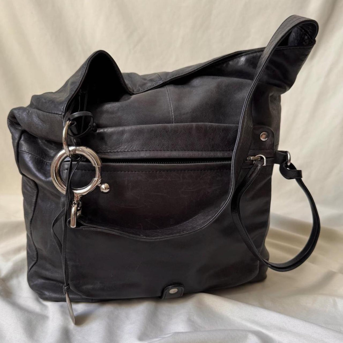Y2k distressed black leather bag with chunky silver hardware.